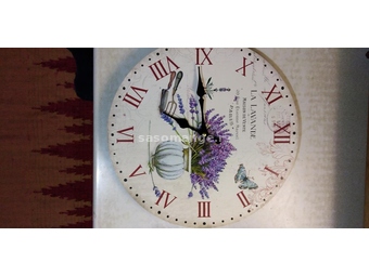 Zidni sat sa slikovitim brojčanikom. Prečnik: 34 cm. Debljina: 5 mm. Materijal: Karton.